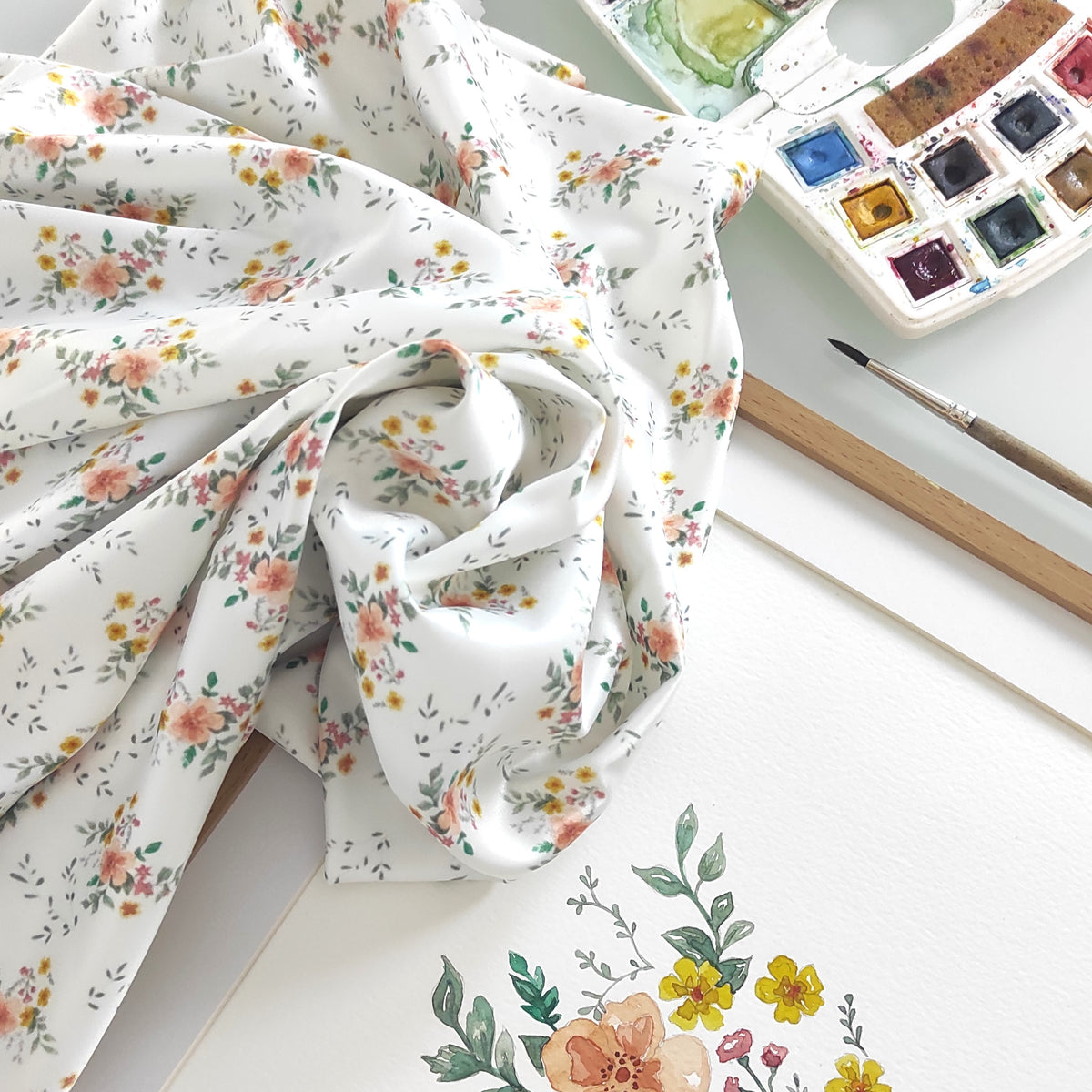 Tissu placé à côté du dessin original réalisé en aquarelle.
