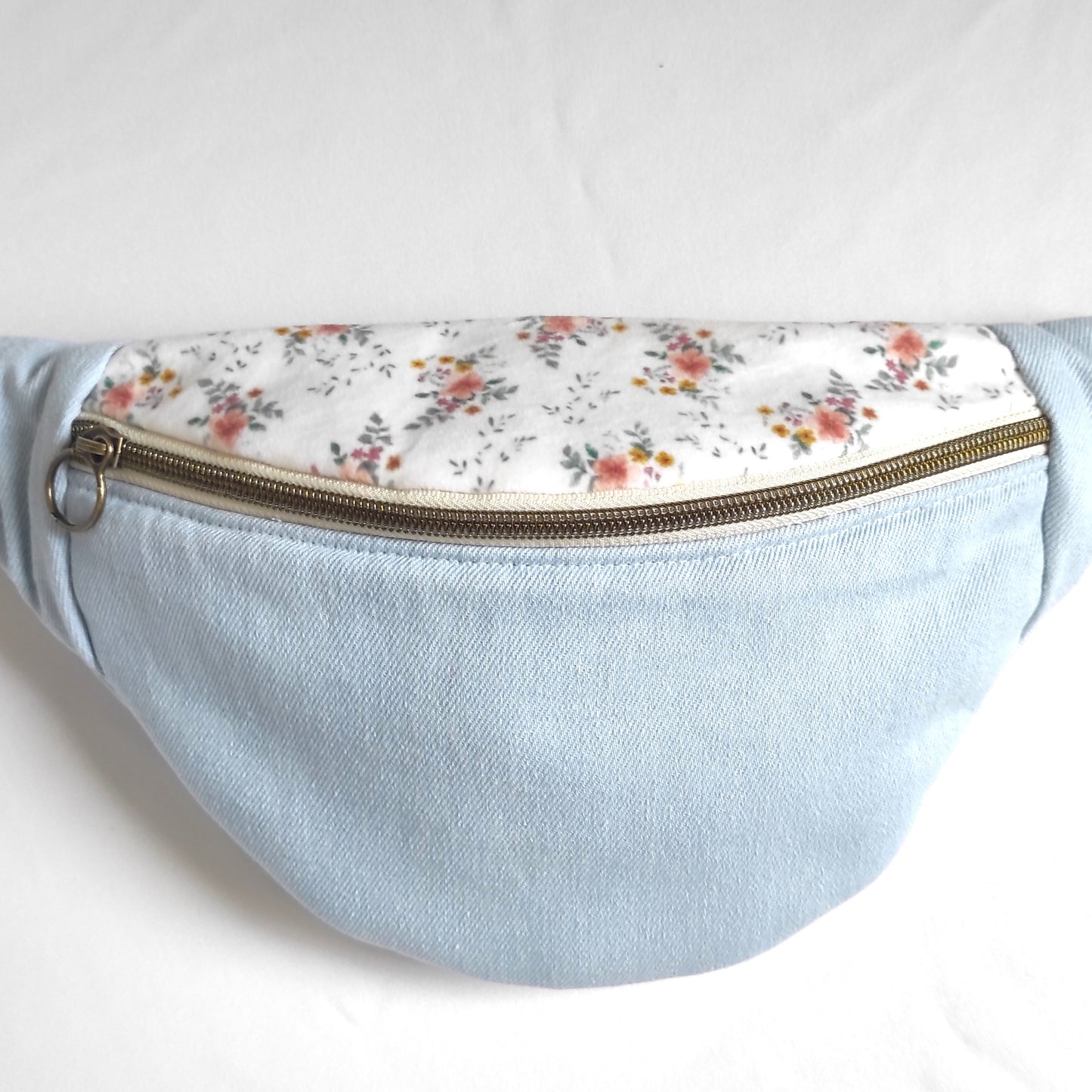 Détail du sac banane en jean et motif fleuri vue de face.