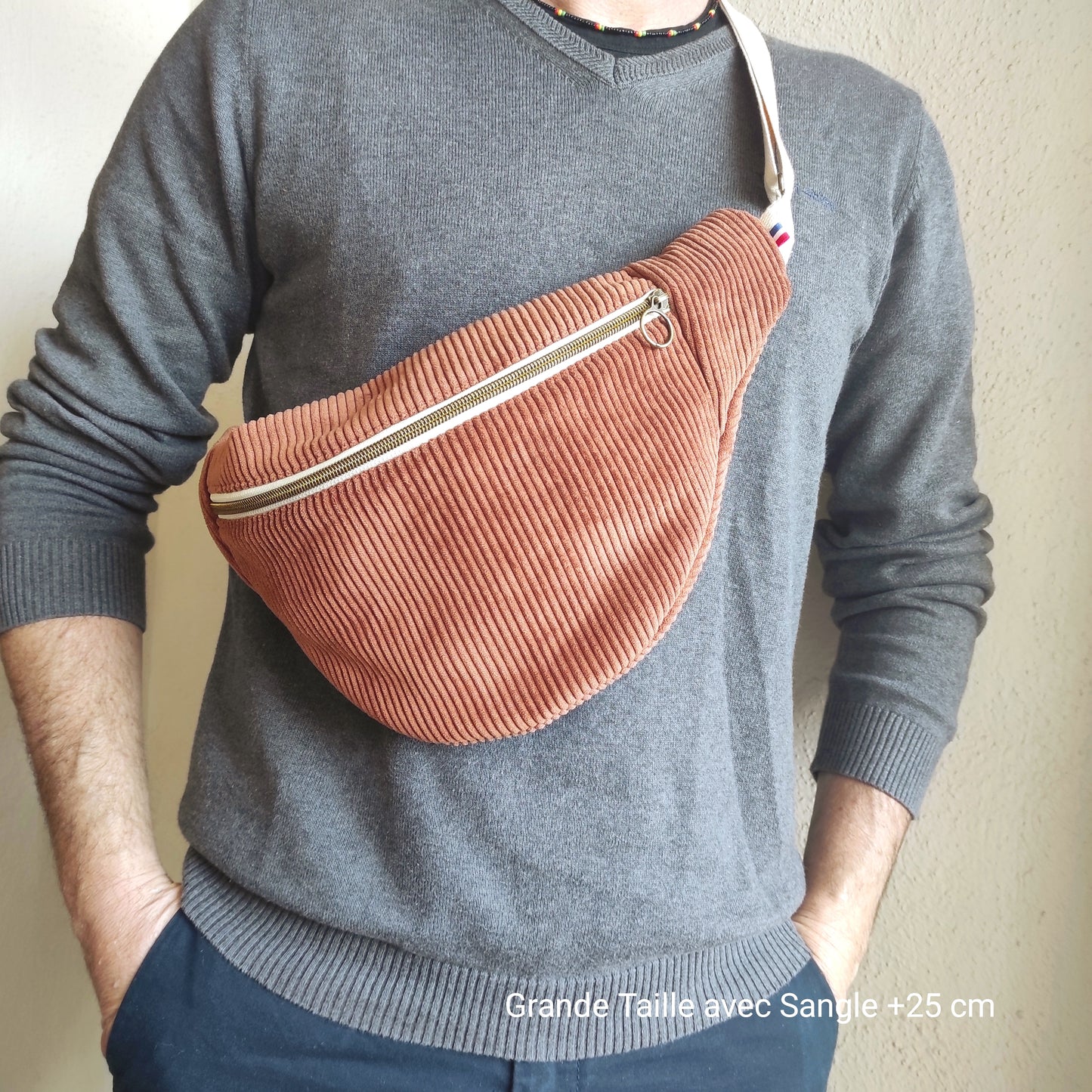 Banane en velours côtelé marron grande taille avec sangle écrue et rallongée de 25 cm. La banane est portée en bandoulière sur un homme.