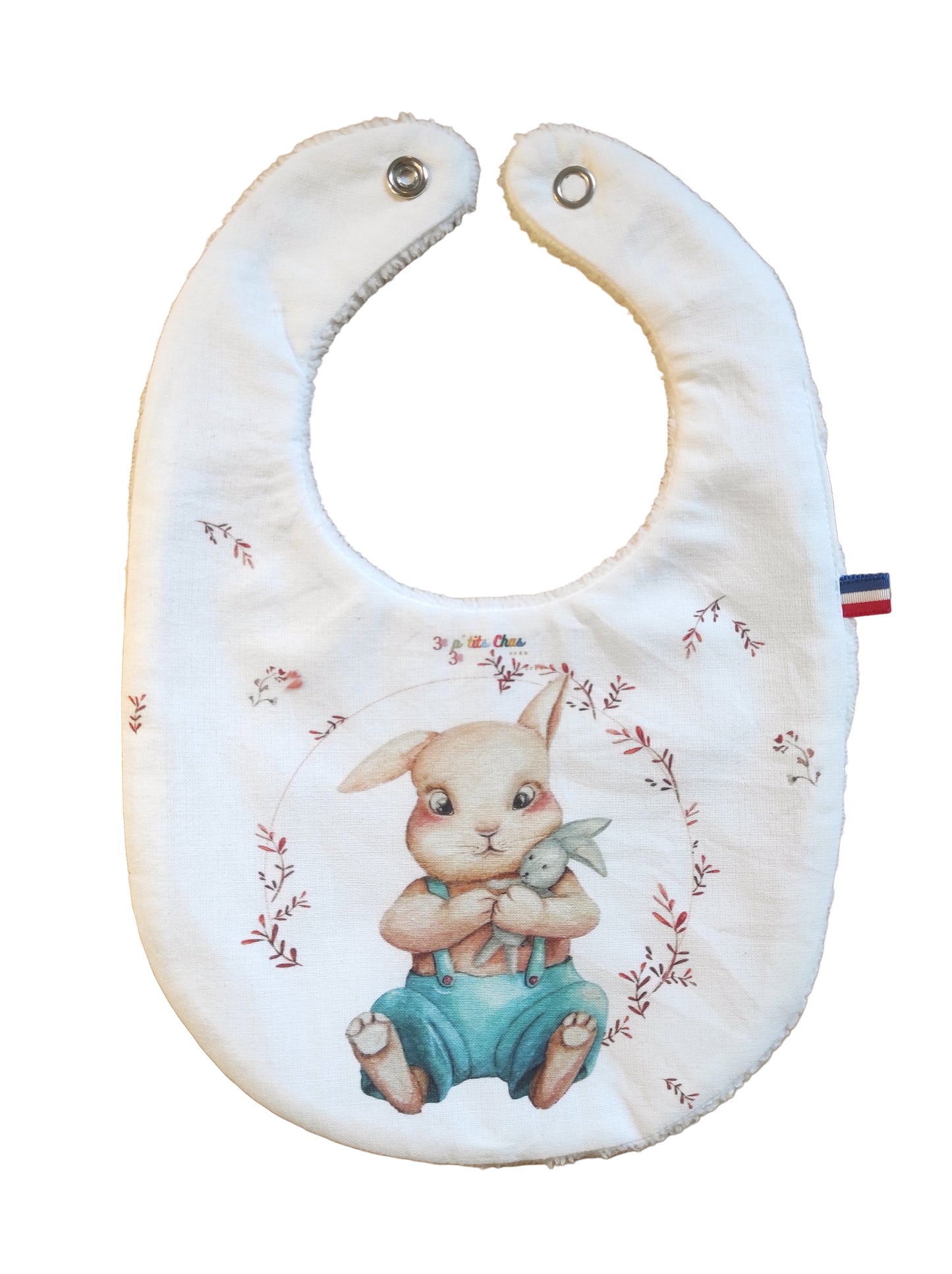 Bavoir avec motif lapin et son doudou lapin dans ses bras. 
