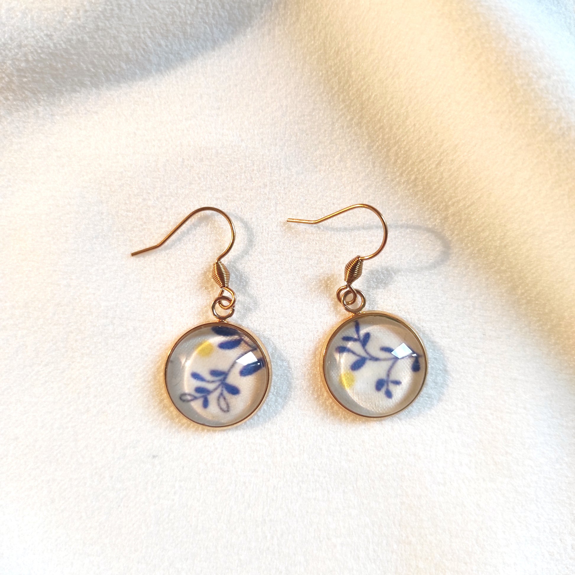 Boucles d'oreille acier inoxydable doré, motif mimosa, feuilles stylisées bleues avec point jaune pour représenter le mimosa. Taille du pendentif 12 mm.