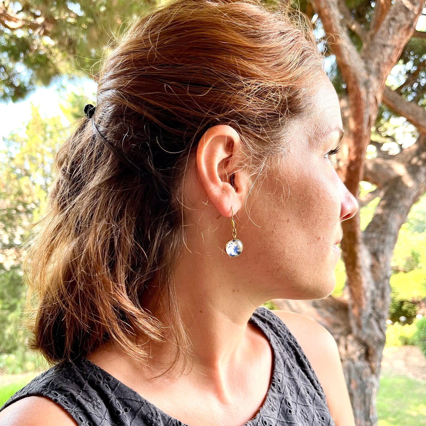 Les boucles sont en acier inoxydable certifié doré, avec perle en verre et tissu fleurs bleues. 