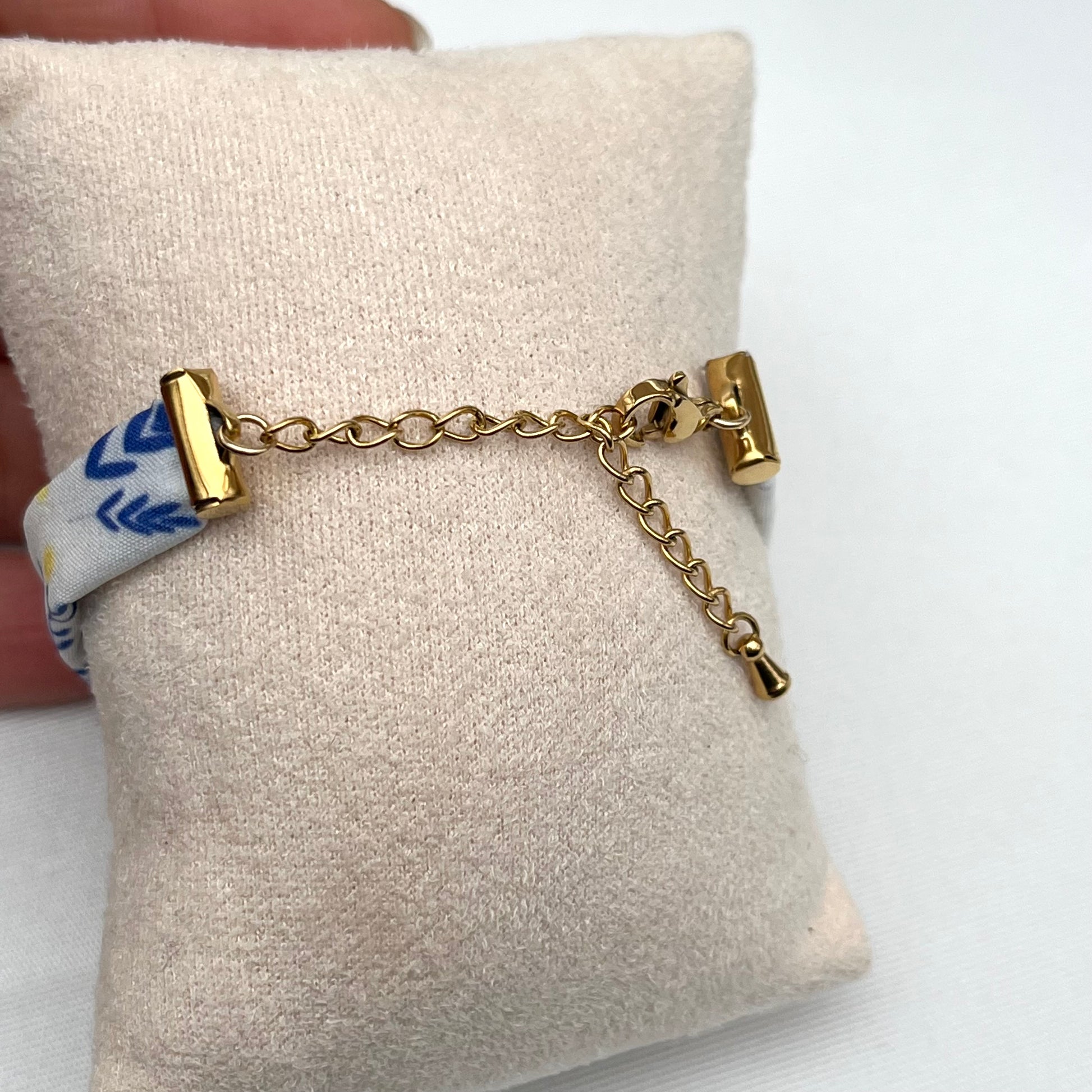 Bracelet en tissu signé Fanny Agustin, le motif est bleu jaune et blanc, il représente du mimosa. Le fermoir est doré et réglable.