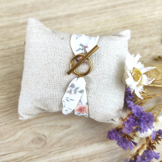 Bracelet en tissu avec motif fleuri dessiné par Fanny Agustin à l'aquarelle puis imprimé localement. Le bracelet est fermé avec fermoir en T couleur doré.