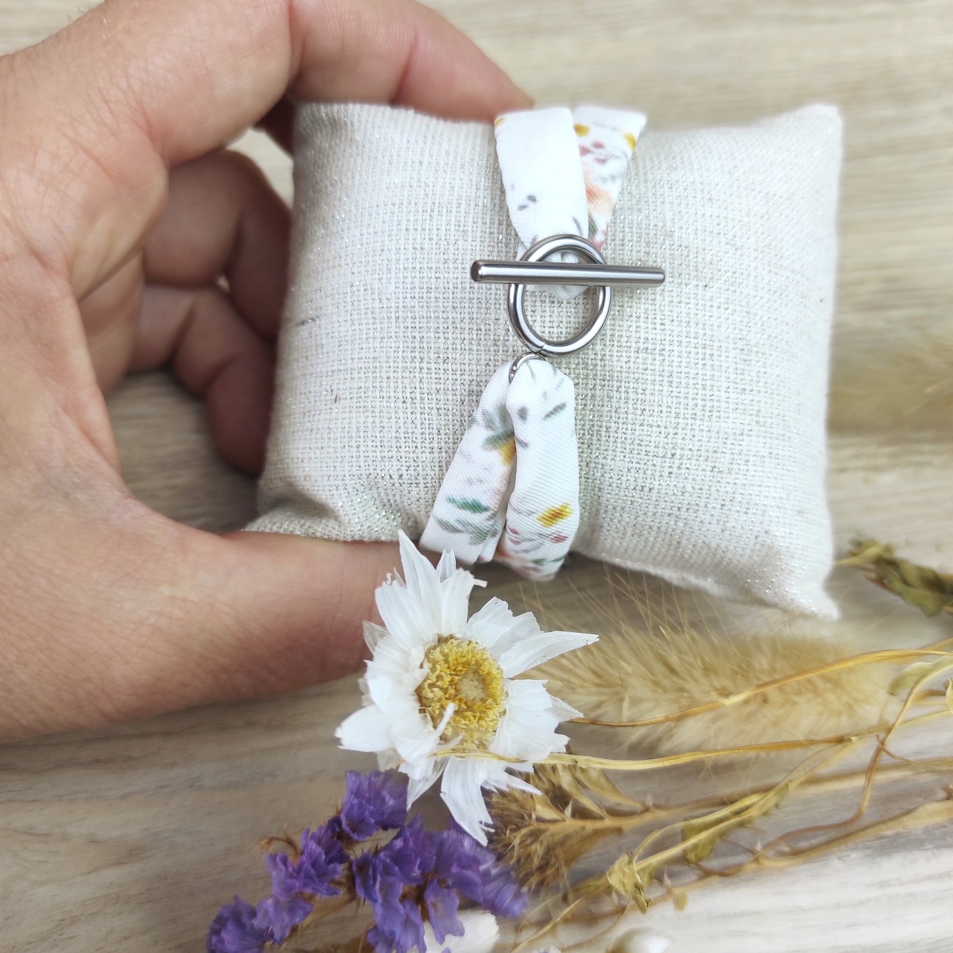 Bracelet en tissu avec motif fleuri dessiné par Fanny Agustin à l'aquarelle puis imprimé localement. Le bracelet est fermé avec fermoir acier inoxydable en T couleur argent.