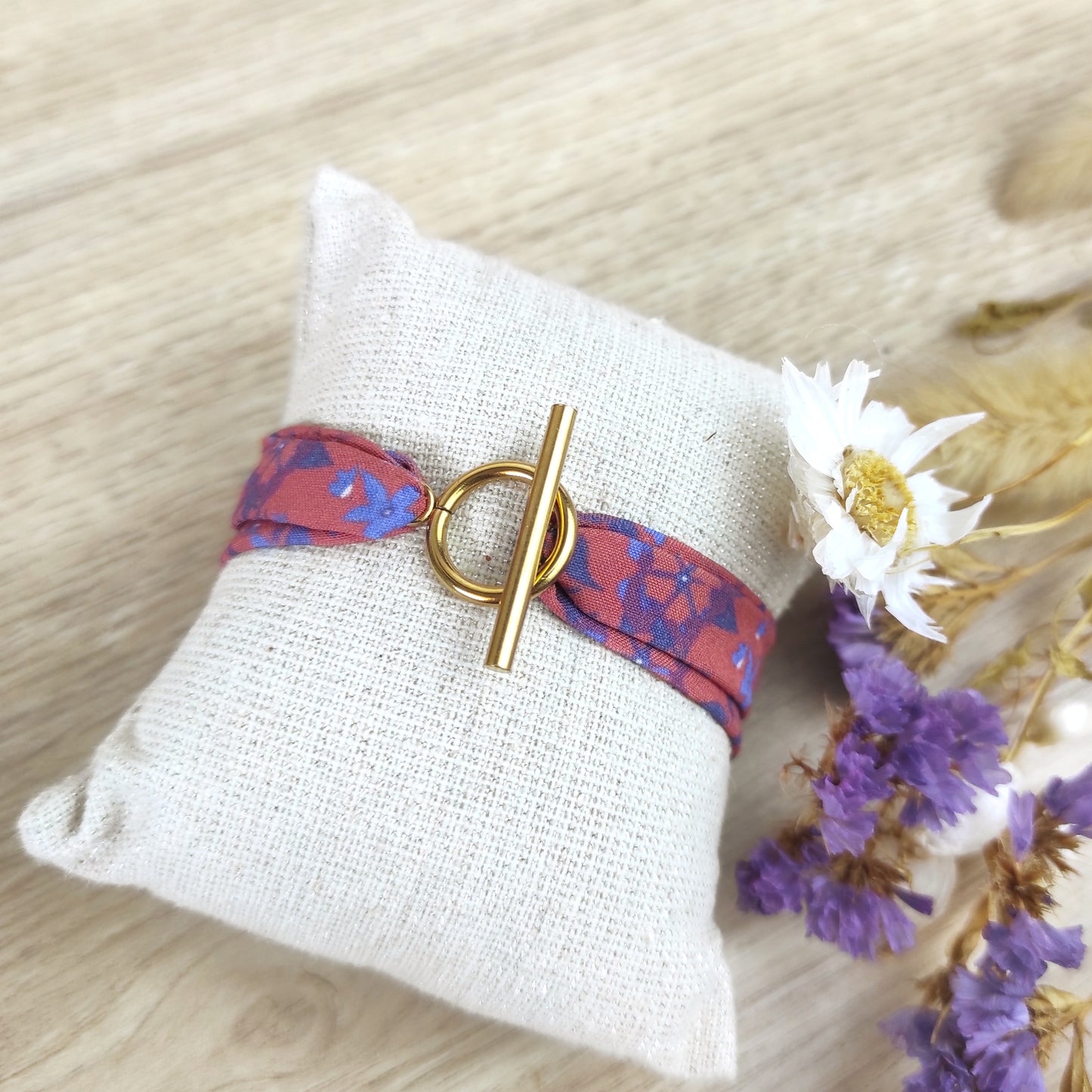 Bracelet tissu motif fleurs bleues fond paprika et fermoir doré, dessiné par Fanny Agustin.