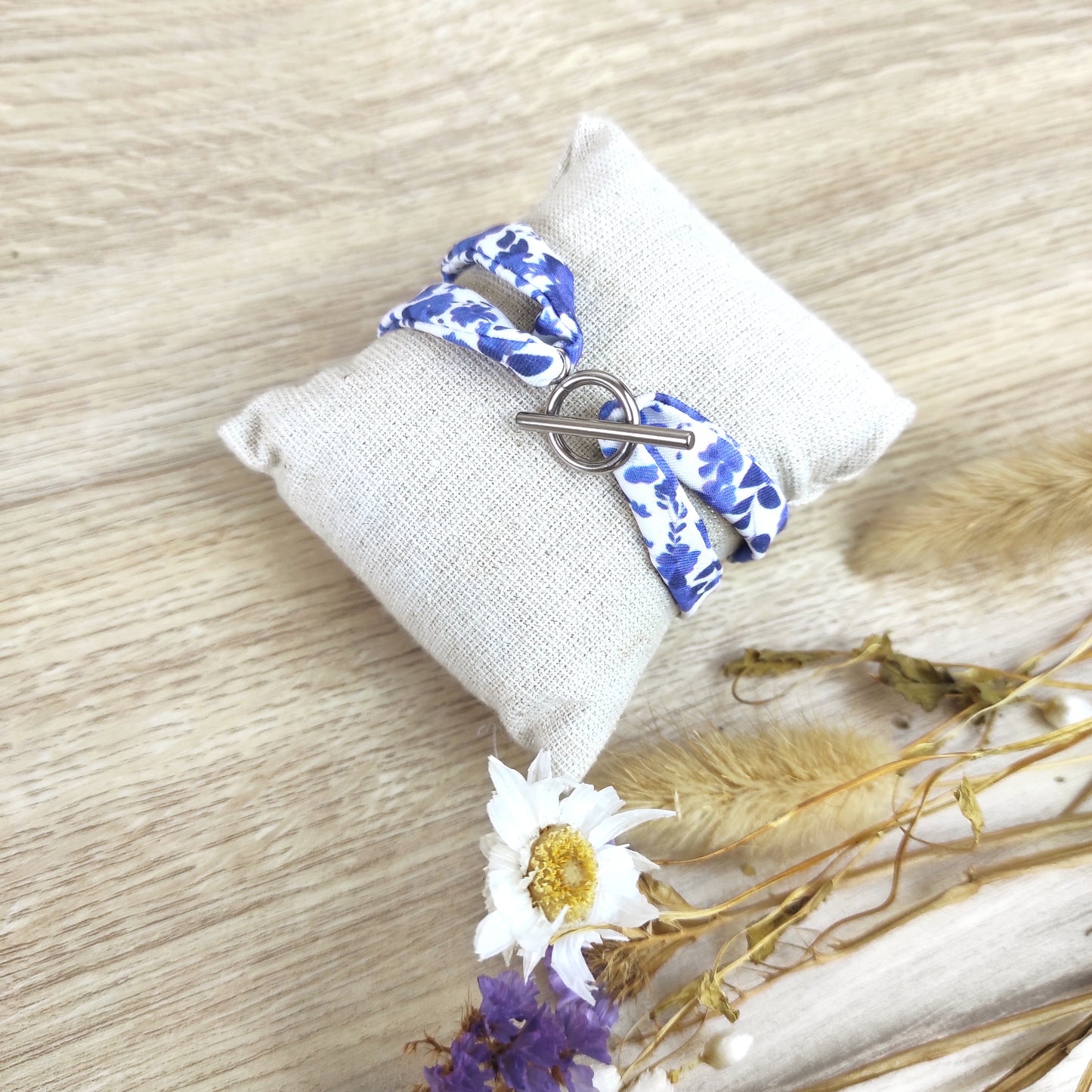 Bracelet tissu motif fleurs bleues avec fermoir en acier inoxydable couleur argent, motif dessiné par Fanny Agustin.