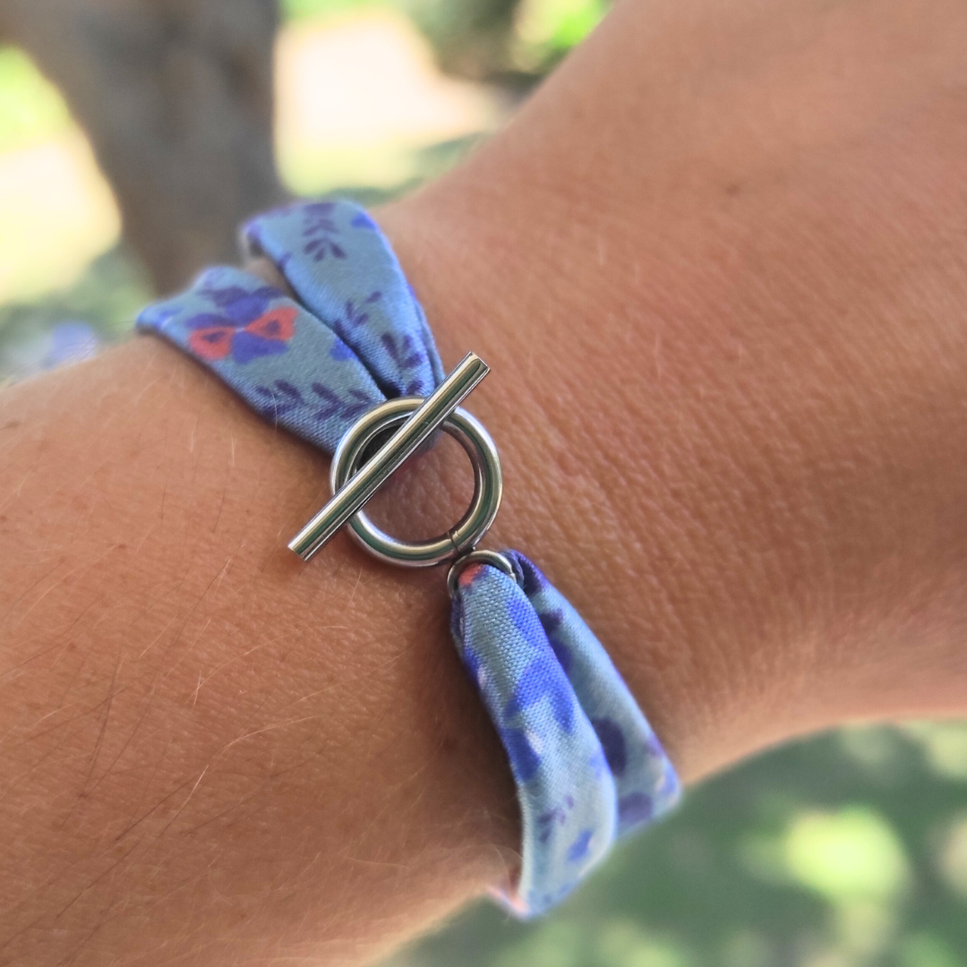 Bracelet en tissu satin motif fleuri bleu avec fermoir anneau en acier inoxydable.