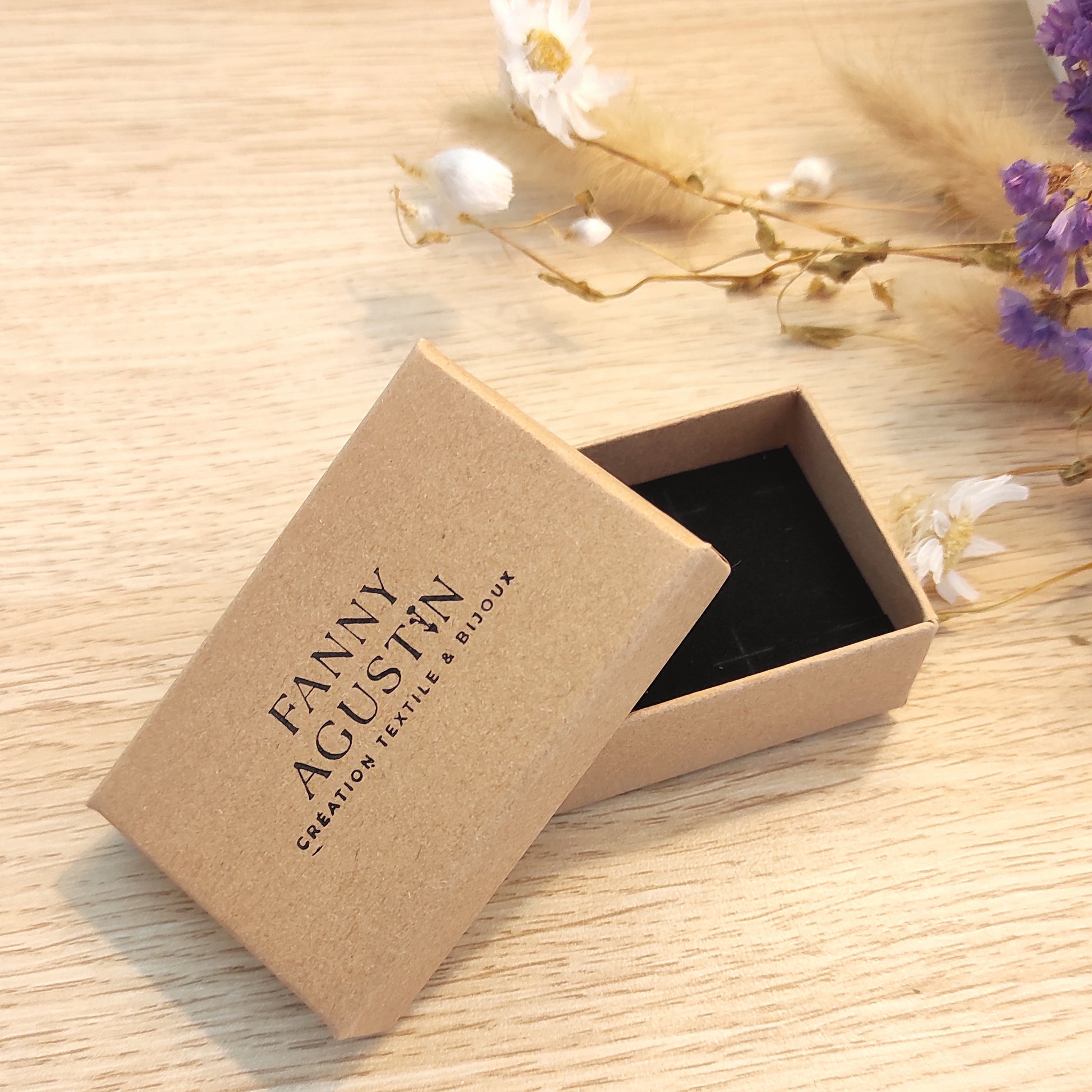 Coffret à bijoux avec logo Fanny Agustin, coffret cartonné avec intérieur noir.
