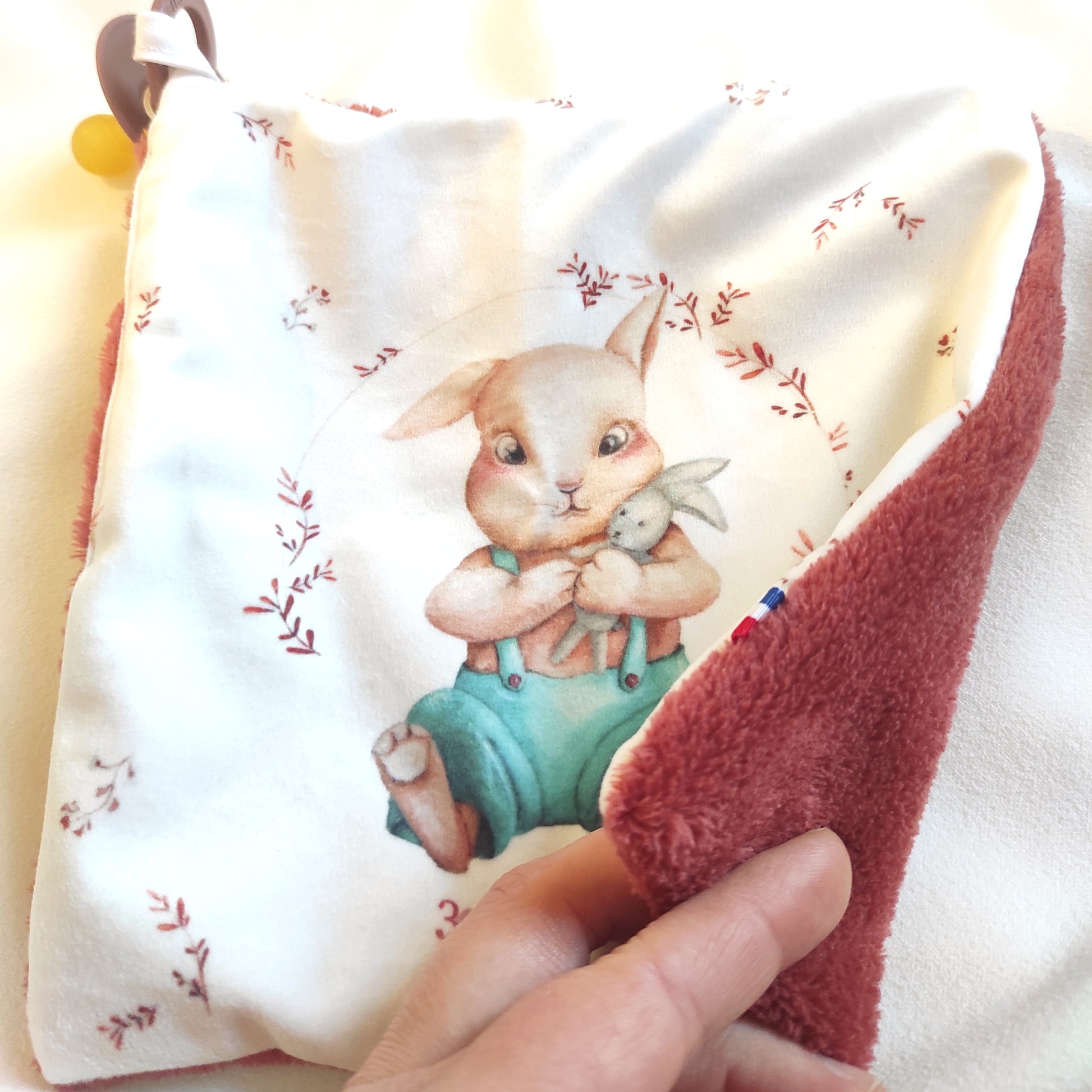 Doudou lapin en velours avec envers en maille peluche couleur paprika.