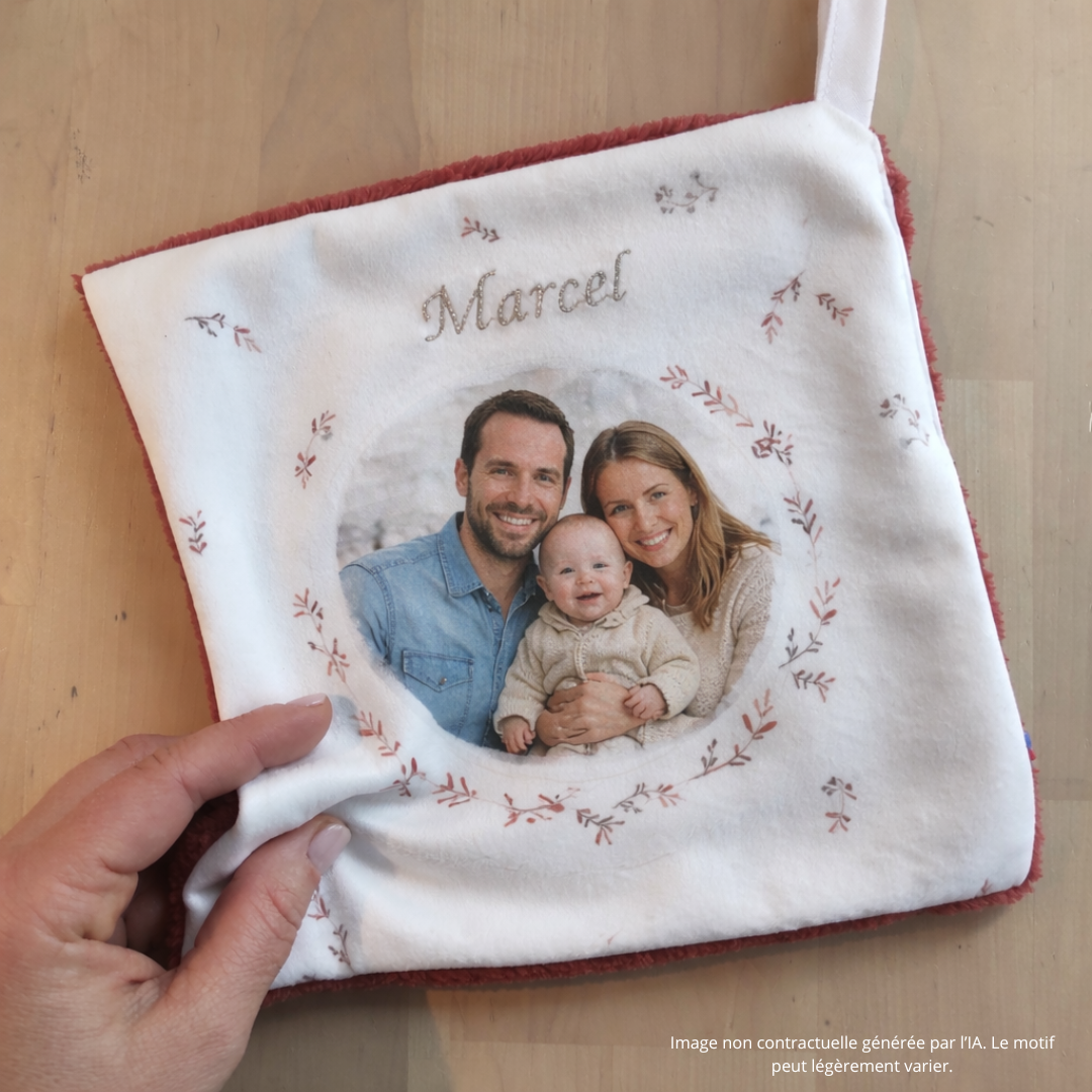 Doudou personnalisable fabrication main Française par Fanny Agustin. Impression de la photo de famille sur tissu certifié, doudou carré avec fond blanc, feuillage autour de la photo, prénom brodé doré.