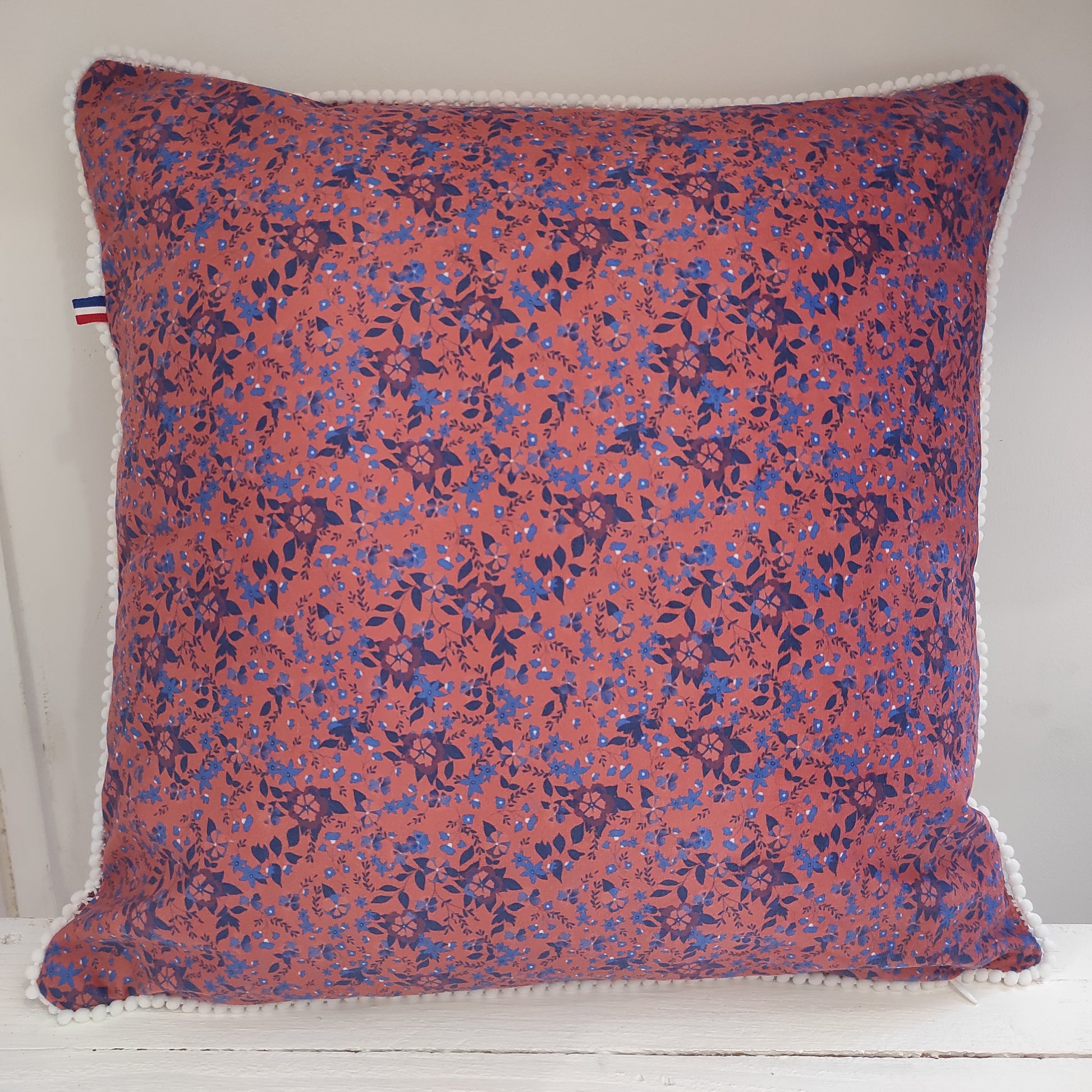 Coussin velours fleurs bleues fond paprika