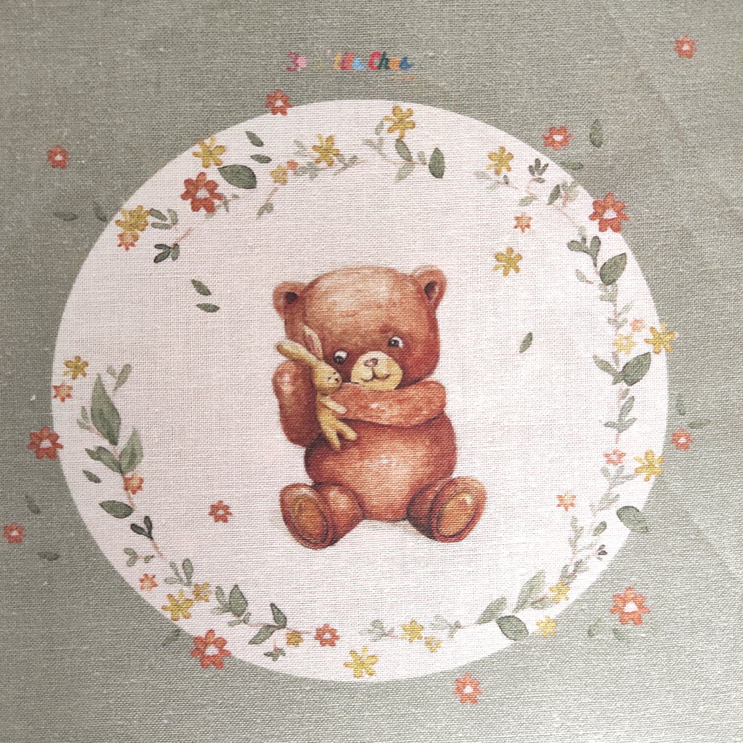 Ourson dessiné à l'aquarelle puis imprimé sur tissu en coton. Dessin exclusifs de FANNY AGUSTIN. L'ourson tient un doudou dans ses bras et est entouré de feuillage et fleurs marrons, jaunes et oranges.