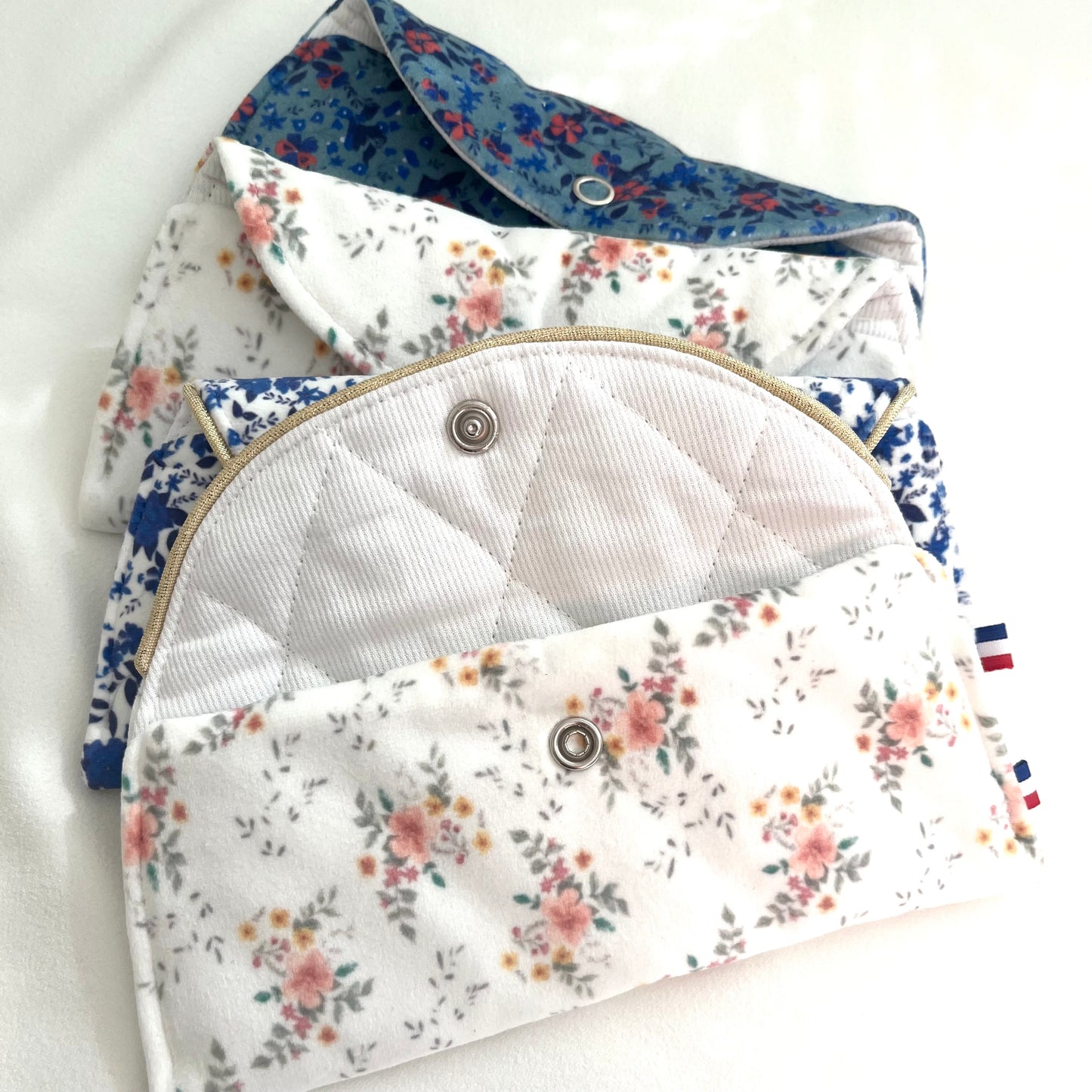 Pochettes à lunettes en velours imprimé, motifs dessinés par Fanny Agustin et fabrication artisanale Française. Une des pochettes est ouverte est laisse apparaître l'intérieur matelassé blanc et pression. 