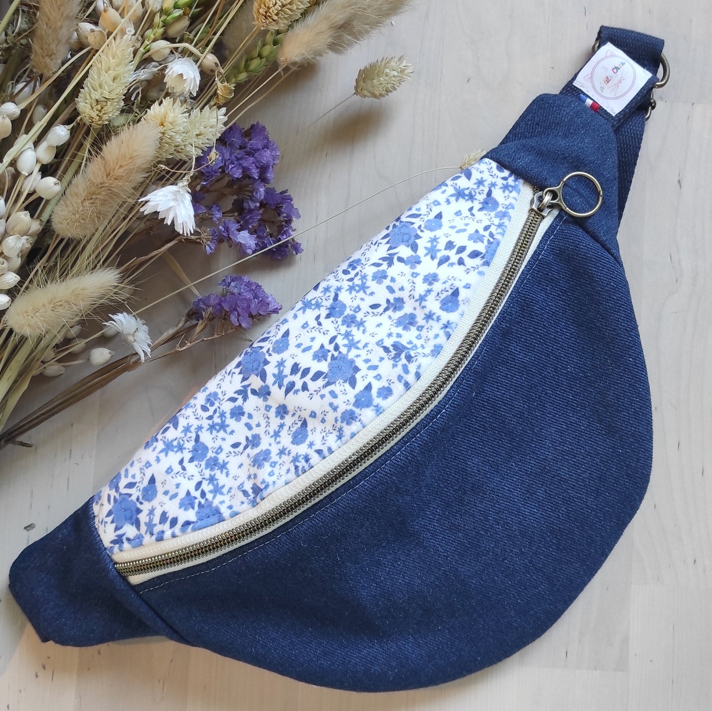 Banane jean foncé avec tissu velours fleuri fleurs bleues. Le motif est blanc et bleu. La fermeture couleur bronze. Banane conçue par Fanny Agustin, motif, patron et couture. 