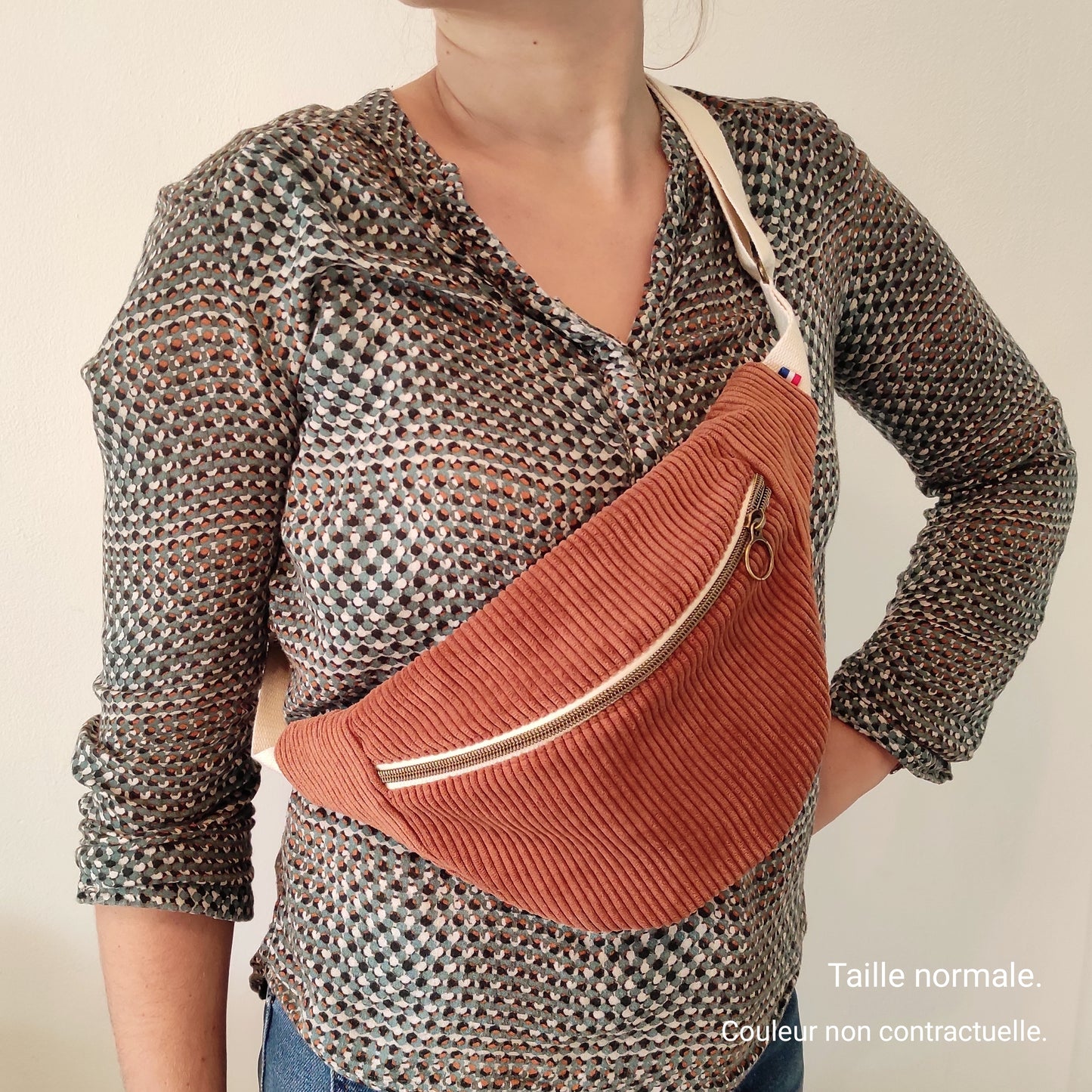 Sac porté en bandoulière sur femme avec une sangle écrue. Le sac peut aussi convenir pour des hommes.