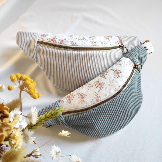 Fabrication artisanale de sacs bananes, ici 2 bananes sont placées au centre, une en velours côtelé couleur écru, l'autre vert de gris, et le dessus avec un tissu en velours fleuri, motif dessiné à l'aquarelle par Fanny Agustin et imprimé localement.