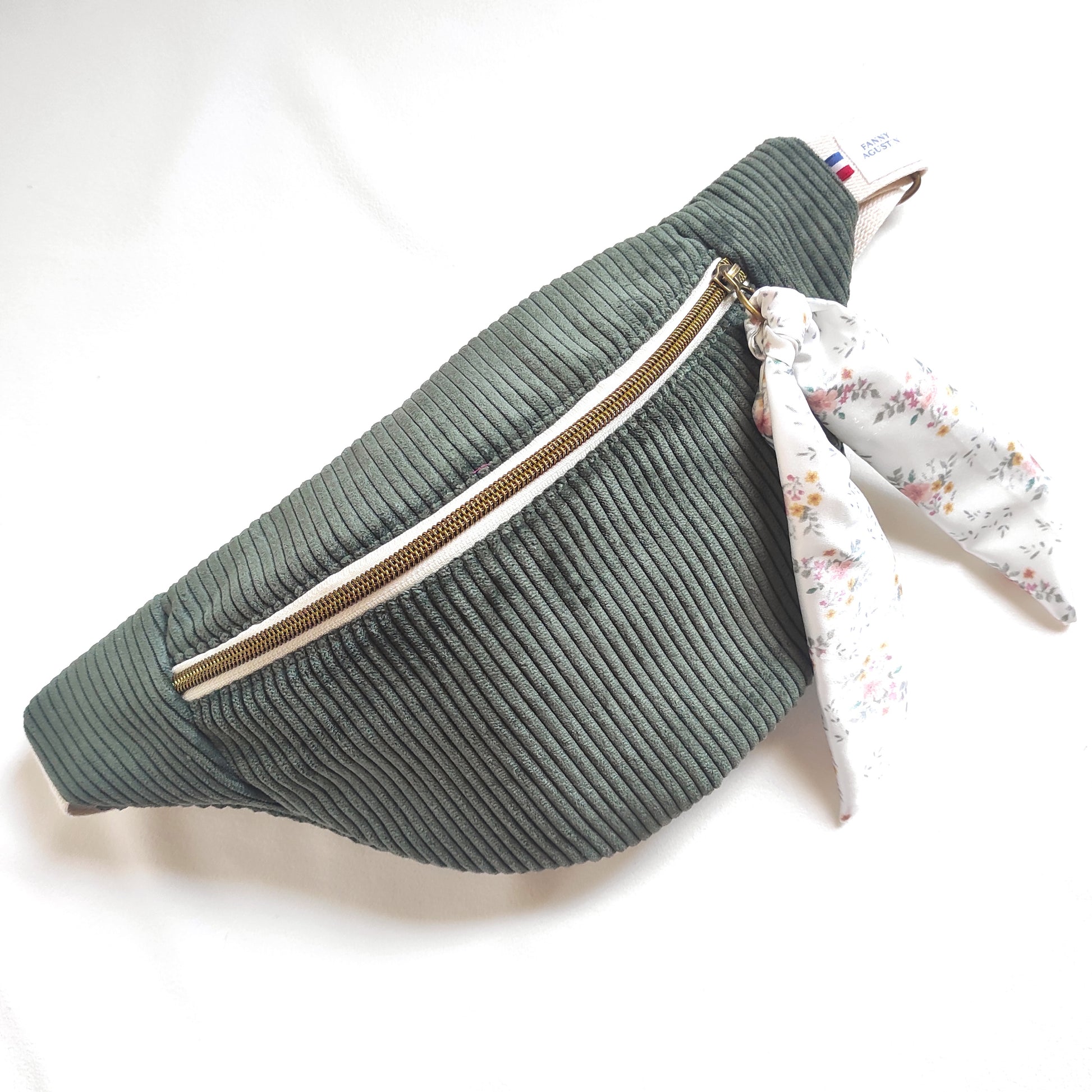 Sac banane en velours côtelé vert kaki avec ruban amovible fleuri dont les motifs sont dessinés par Fanny Agustin.